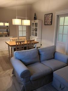 uma sala de estar com um sofá azul e uma mesa em Casa Busche - Piccola Suite in Campagna Con Ampio Giardino em Gualdo Tadino