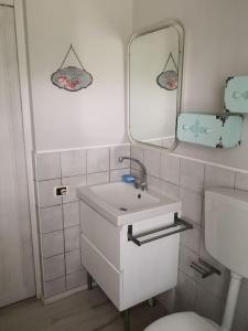 a bathroom with a sink and a mirror and a toilet at Casa Busche - Piccola Suite in Campagna Con Ampio Giardino in Gualdo Tadino