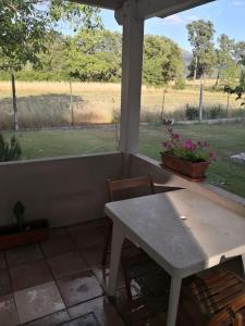 una mesa y sillas en un porche con vistas a un campo en Casa Busche - Piccola Suite in Campagna Con Ampio Giardino, en Gualdo Tadino