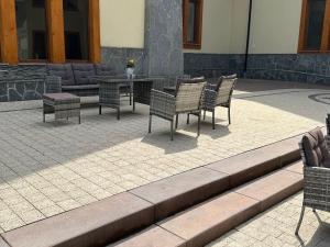 ApartHotel Tatry de Luxe FizjoMedical & Spa في مورزاسيخله: مجموعة من الكراسي والطاولات على الفناء