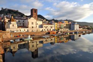 a city with a reflection in a body of water at Sardinian Gallery Corso in Bosa