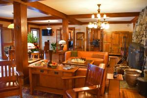 a living room filled with wooden furniture and a table at Chestnut Inn at Oquaga Lake in Deposit