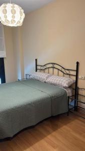 sypialnia z łóżkiem i żyrandolem w obiekcie El Ñeru'l Cantu w mieście Villaviciosa