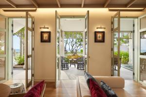 a living room with sliding glass doors leading to a patio at Charras Bhawan Hotel and Residences in Hua Hin