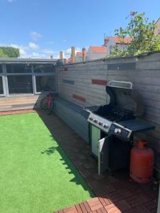 een buitengrill in een achtertuin met een gazon bij Family Holiday Home in Blackpool