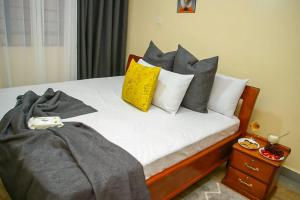 a bed with pillows on it with at Jaymorgan' Cabins. in Nyeri