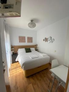 Dormitorio blanco con cama y mesa en Habitación intima con patio privado, 