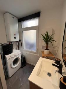 a small kitchen with a washing machine and a window at Beau Loft room proche mont saint Michel jaccuzi illimité en plein centre Avranches in Avranches
