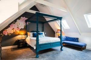 a bedroom with a blue canopy bed and a blue bench at The Crag in Wadebridge