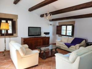 sala de estar con 2 sillas blancas y TV en Villa Encanto en Tordera