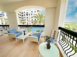 balcone con sedie, tavoli e vista su un edificio di Luxury Golf View For Family 203A3 a Abu Dhabi