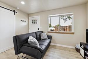 un sofá de cuero negro en una sala de estar con ventana en Lewiston Vacation Rental Near Clearwater River! en Lewiston