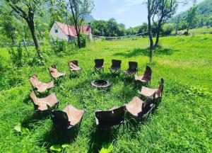 een cirkel van stoelen in het gras in een veld bij UNDER STARS HOUSE in Vermosh