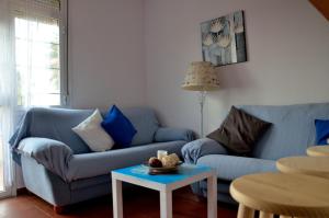 a living room with two blue couches and a table at Apartamento Cosmos Sur in Tarifa