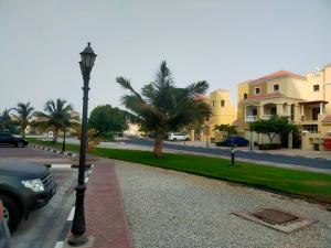 a street light next to a street with palm trees at Sea View Studio 5 Royal Breeze سي ويو ستوديو رويال بريز in Ras al Khaimah