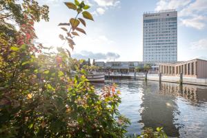 Blick auf einen Fluss mit einem hohen Gebäude in der Unterkunft Mercure Hotel Potsdam City in Potsdam