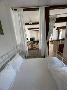 um quarto com uma cama branca e uma sala de estar em Gite d'Ecosse em Azille