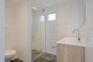 Un baño con inodoro, lavabo y ducha. en Vakantiehuis Duyngans - Julianadorp aan Zee, en Julianadorp 15 fotos más