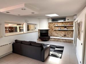 a living room with a couch and a fireplace at Villa Belvedere Versilia - Villa con tre camere, cucina, sala, giardino con piscina e vista - 7 posti letto in Camaiore