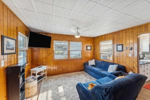 uma sala de estar com um sofá azul e uma televisão em Delavan Retreat with Patio on Turtle Lake! em Elkhorn