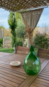 zielony szklany wazon siedzący na drewnianym stole w obiekcie Bio&B Acquaviva w mieście Otranto
