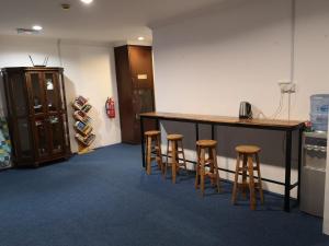 Zimmer mit einer Bar mit drei Stühlen und einer Theke in der Unterkunft AeCOTEL in Sandakan
