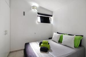 1 dormitorio con 1 cama con almohadas verdes y blancas en Aldeia das açoteias, en Albufeira