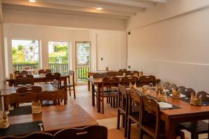 Eden Hill Hotel في نوارا إليا: غرفة طعام مع طاولات وكراسي خشبية