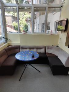 ein Wohnzimmer mit einem Sofa und einem Tisch in der Unterkunft ЛИДЕР ХАУС ХОСТЕЛ in Warna