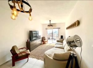 a living room with a couch and a tv at Modern 3BDR in Acropolis-Nicosia in Strovolos