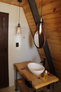 a bathroom with a white bowl on a wooden table at Canda Cabana com SPA e vista para Cachoeiras in Baependi +40 photos