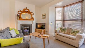 uma sala de estar com um sofá e uma lareira em Beechwood House em The Mumbles