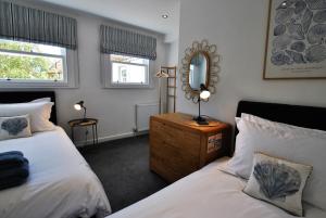 a bedroom with two beds and a mirror at Murrays Neuk- stylish coastal apartment in Anstruther