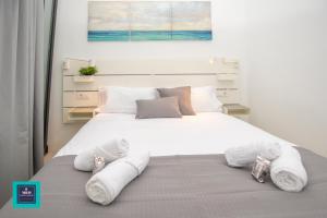 a bedroom with a large white bed with towels on it at Vegueta Old Town, Las Palmas in Las Palmas de Gran Canaria