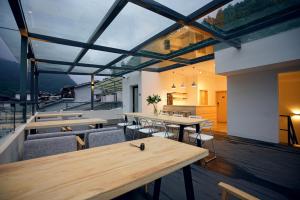 un restaurante con mesas y sillas y un balcón en Travel of Swan International Hostel en Zhangjiajie
