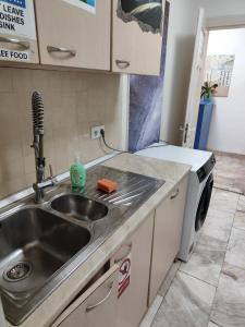 uma cozinha com um lavatório e uma máquina de lavar roupa em ЛИДЕР ХАУС ХОСТЕЛ em Varna City
