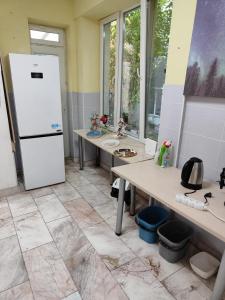 a kitchen with a white refrigerator and a table at ЛИДЕР ХАУС ХОСТЕЛ in Varna City