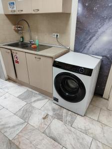 uma máquina de lavar roupa numa cozinha ao lado de um lavatório em ЛИДЕР ХАУС ХОСТЕЛ em Varna City
