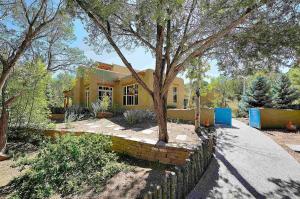 Una casa amarilla con un árbol delante. en Green Acres Santa Fe 8 mins from plaza!, en Santa Fe