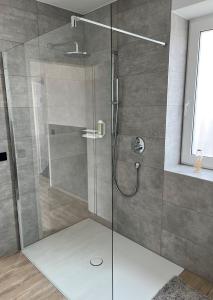 a shower with a glass door in a bathroom at Hotel Papenbreer in Verl