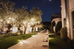 Villa Sirena Hotel e Ricevimenti في Durazzano: صف من المقاعد على الرصيف في الليل