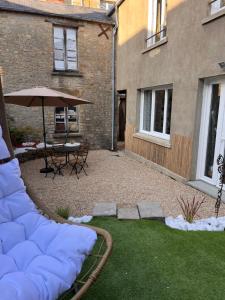een patio met een parasol en een tafel en stoelen bij Beau Loft room proche mont saint Michel jaccuzi illimité en plein centre Avranches in Avranches