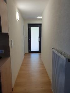 un couloir vide avec une porte et du parquet dans l'établissement Gästehaus Spatzennest Wohnung 2, 