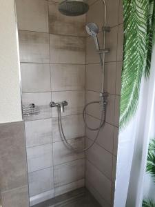 La salle de bains est pourvue d'une douche avec un pommeau de douche. dans l'établissement Gästehaus Spatzennest Wohnung 2, 