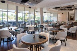 um restaurante com mesas, cadeiras e janelas em Residence Inn by Marriott Miami Airport em Miami