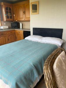 1 dormitorio con 1 cama con manta azul en Music of the Sea- Isle of South Uist, HS8 5RF en Clachan