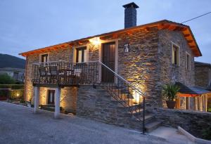 a stone house with a staircase in front of it at Apartamentos Rurales San Xillao in Ribadeo