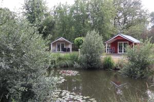 a couple of cottages next to a pond at Lodgepark 't Vechtdal in Dalfsen