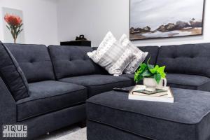 a living room with a blue couch and a table at UrbanUtopia*Luxury Home*King Bed*Patio/BBQ*Sleep16 in Edmonton