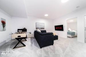 a living room with a couch and a table and a bed at UrbanUtopia*Luxury Home*King Bed*Patio/BBQ*Sleep16 in Edmonton